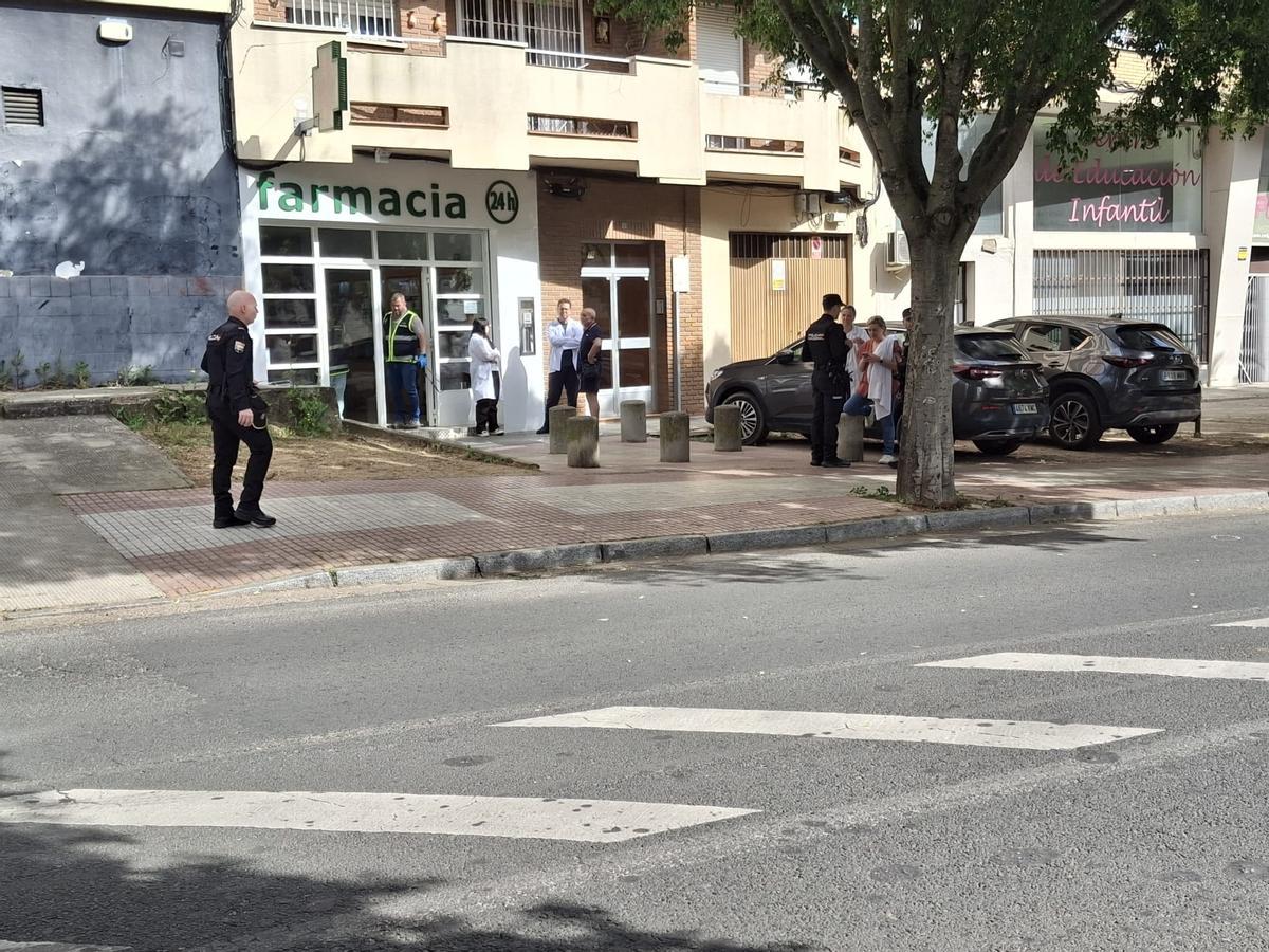 Trabajadores de la farmacia, junto a los agentes de la Policía Nacional, en la avenida Santo Cristo de la Paz.