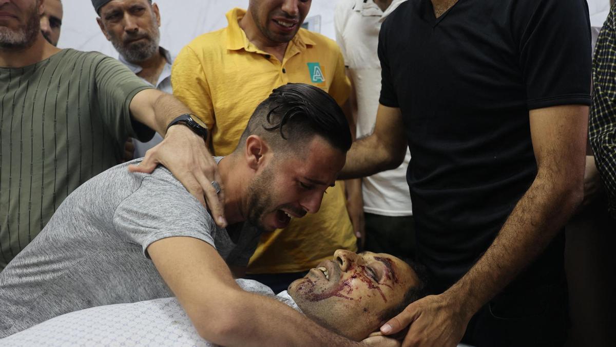 Los familiares de una de las víctimas del ataque israelí en Gaza lloran junto a su cuerpo sin vida.