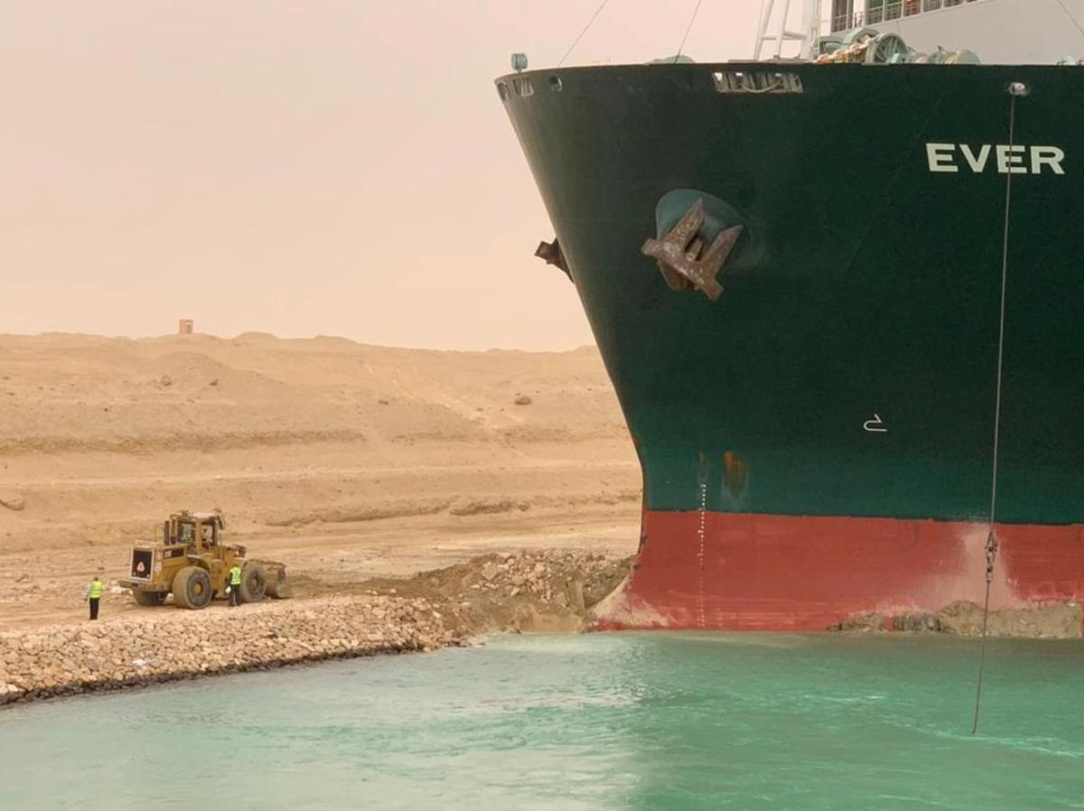 Operarios trabajando para desencallar al 'Ever Given', en el Canal de Suez.