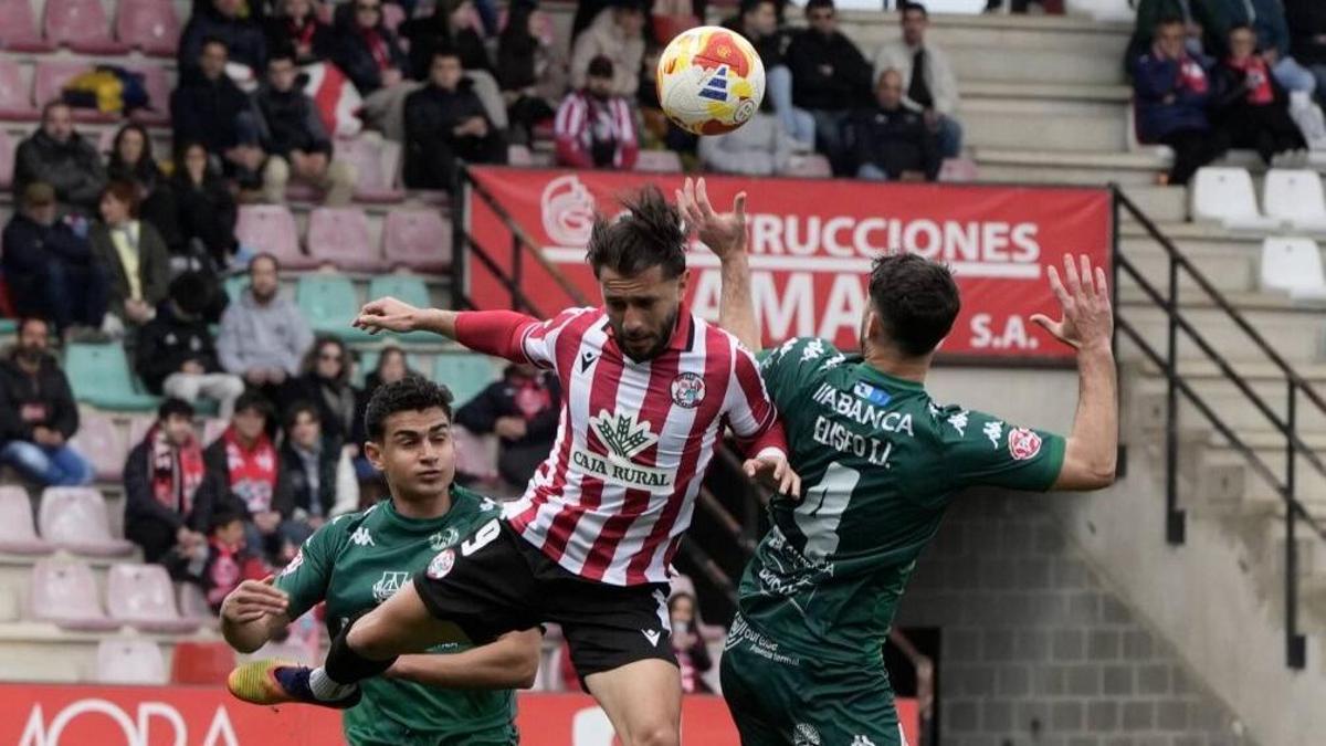 Losada pugna por un balón entre dos defensas del CD Arenteiro