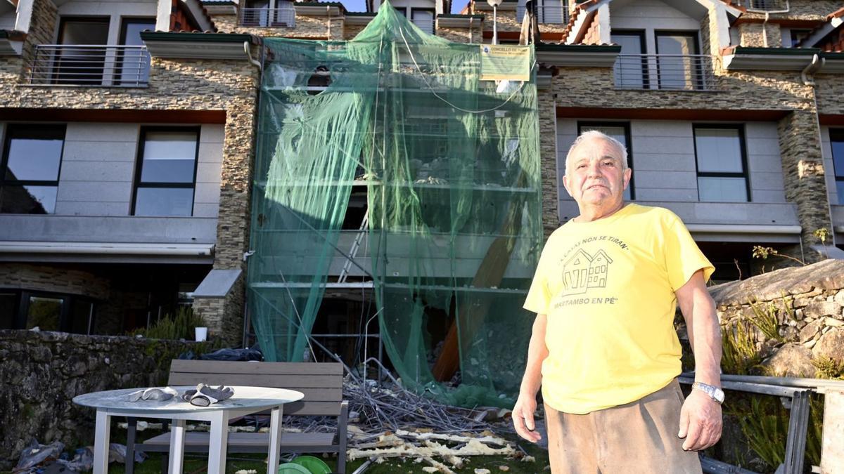 José Rodríguez Piñeiro ante las obras de demolición parcial de la fachada de su chalé de Chancelas, en la tarde de ayer. |   // RAFA VÁZQUEZ