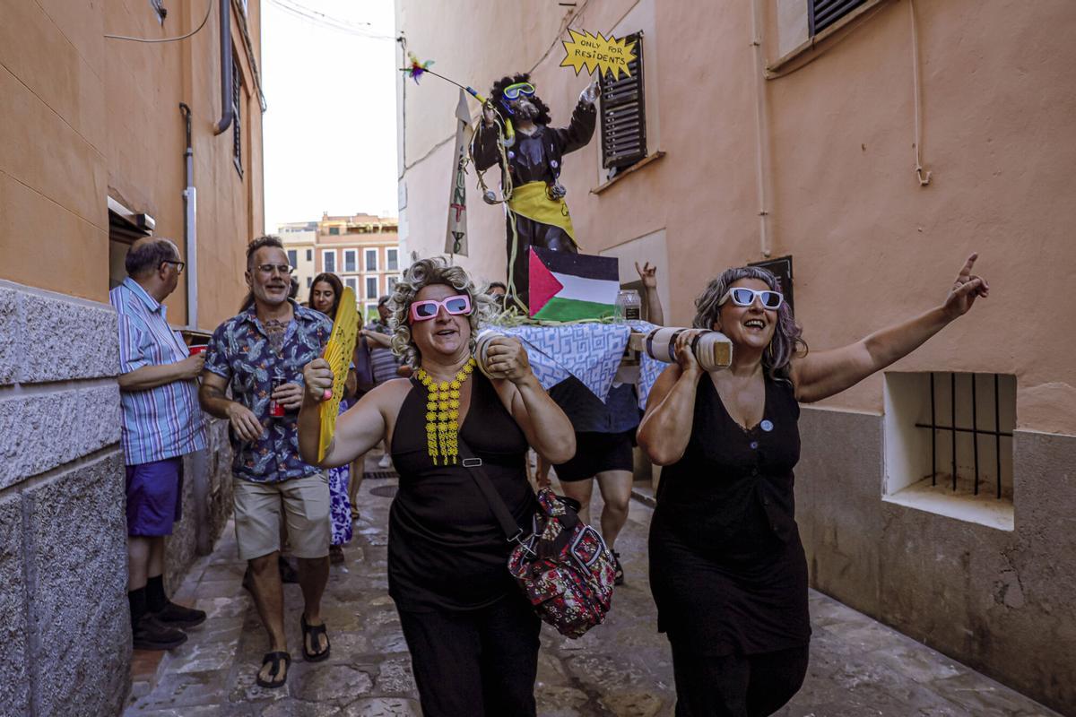 Vecinos de la Calatrava y Canamunt, muchos vestidos de verde y con ramas de árboles, se unen durante sus cercavilas para homenajear a los bellasombras talados en la plaza Llorenç Villalonga.