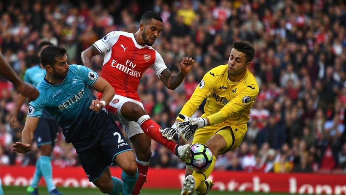 Jordi Amat intenta evitar un remate del delantero del Arsenal Theo Walcott
