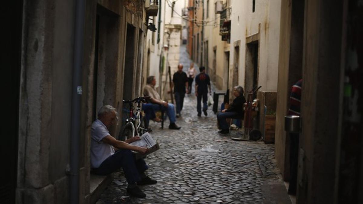 Un hombre lee un diario en el barrio de Alfama, en Lisboa, el miércoles.