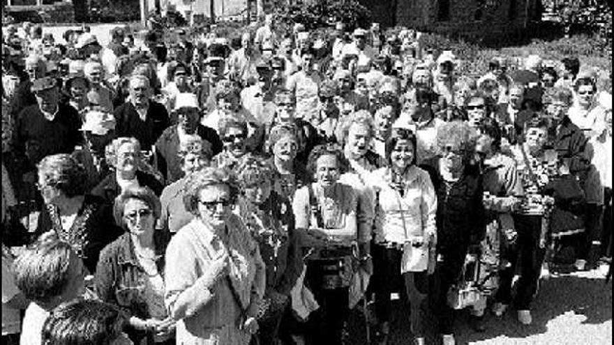 Los participantes en la actividad flanquean a la concejala de Bienestar Social, en la ruta del salmón, en Cornellana.