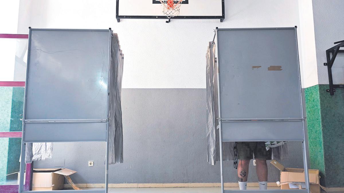 Un hombre vota el 28M en la cabina de un colegio de Cartagena