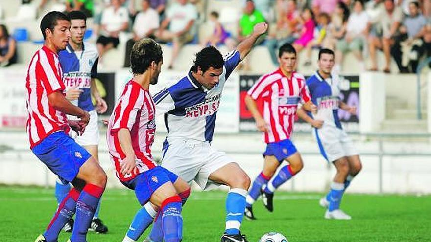 El jugador arlequinado Javi trata de progresar con la pelota ante la oposición de los rojiblancos Guillermo y Lázaro.