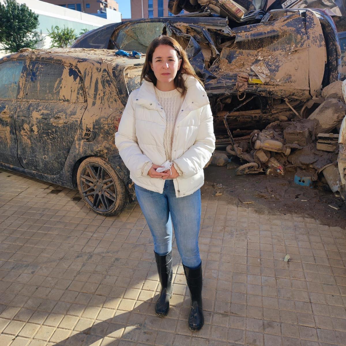 Meri junto al cementerio de coches que tiene en frente de su casa en Catarroja.