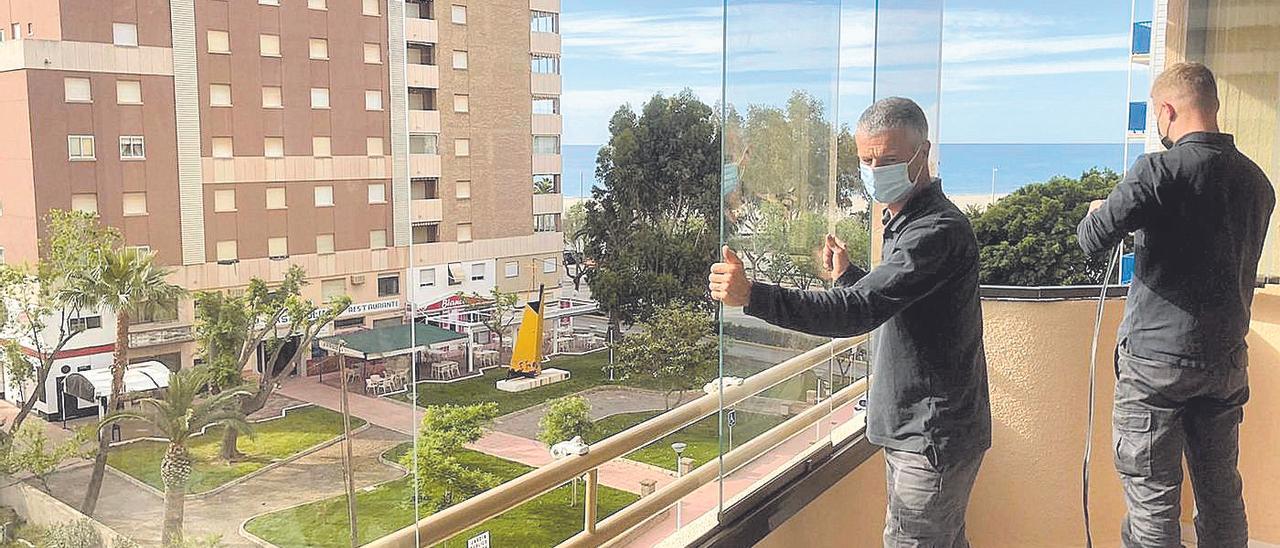 Operarios durante un servicio. Al fondo, comunidades de vecinos de apartamentos que comparten gastos.