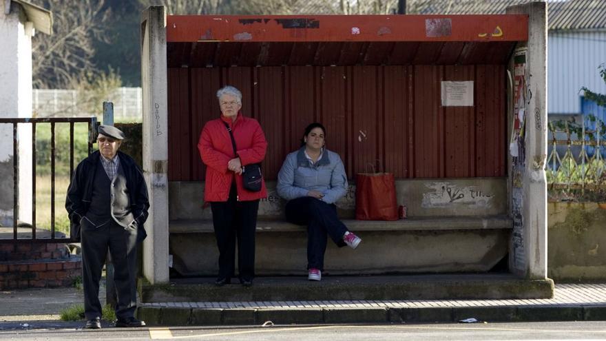 Usuarios en una parada de autobús en Cancienes. | M. López