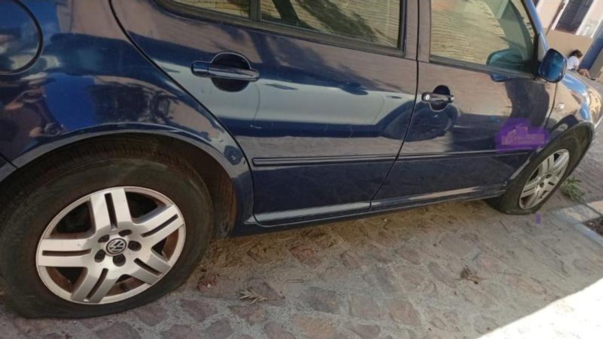 Un vehículo aparcado, con las dos ruedas pinchadas.