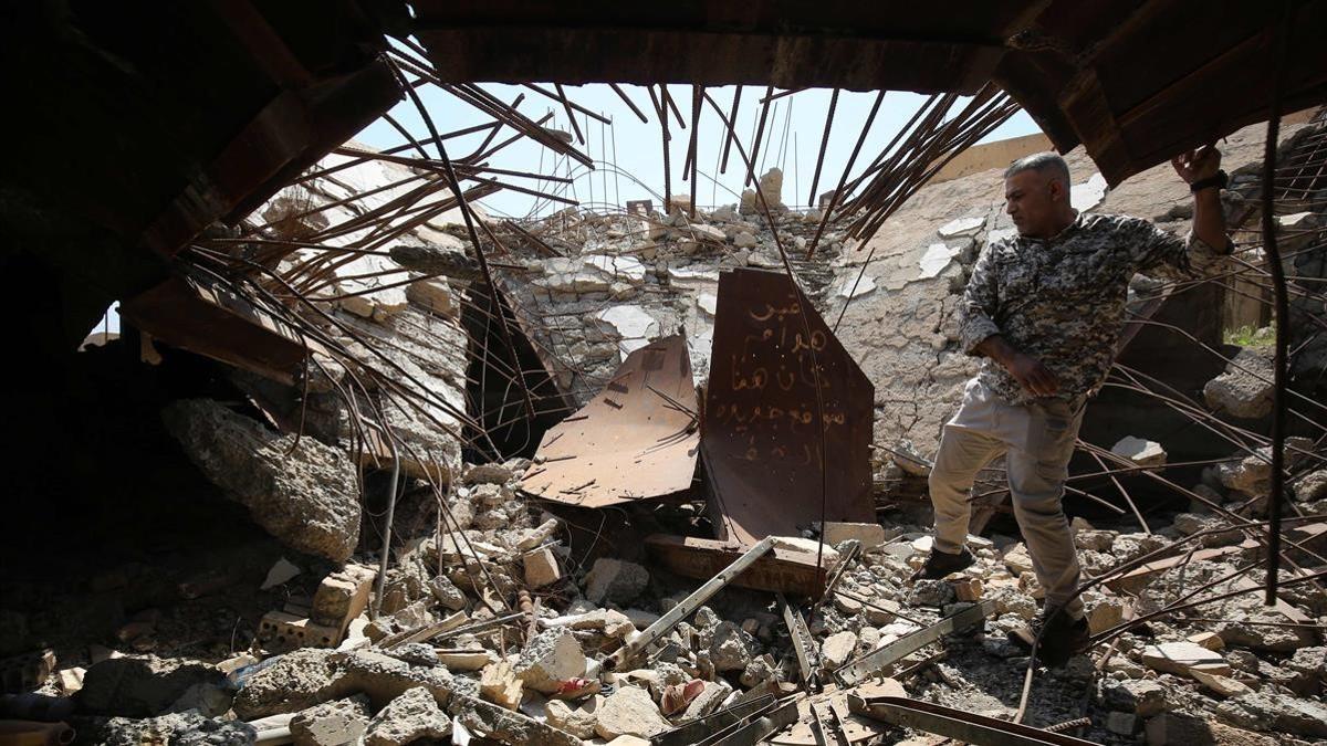 Un soldado de las Fuerzas de Movilización Popular comprueba los restos de la tumba del dictador iraquí Sadam Husein en Ouja, al sur de la ciudad de Tikrit.