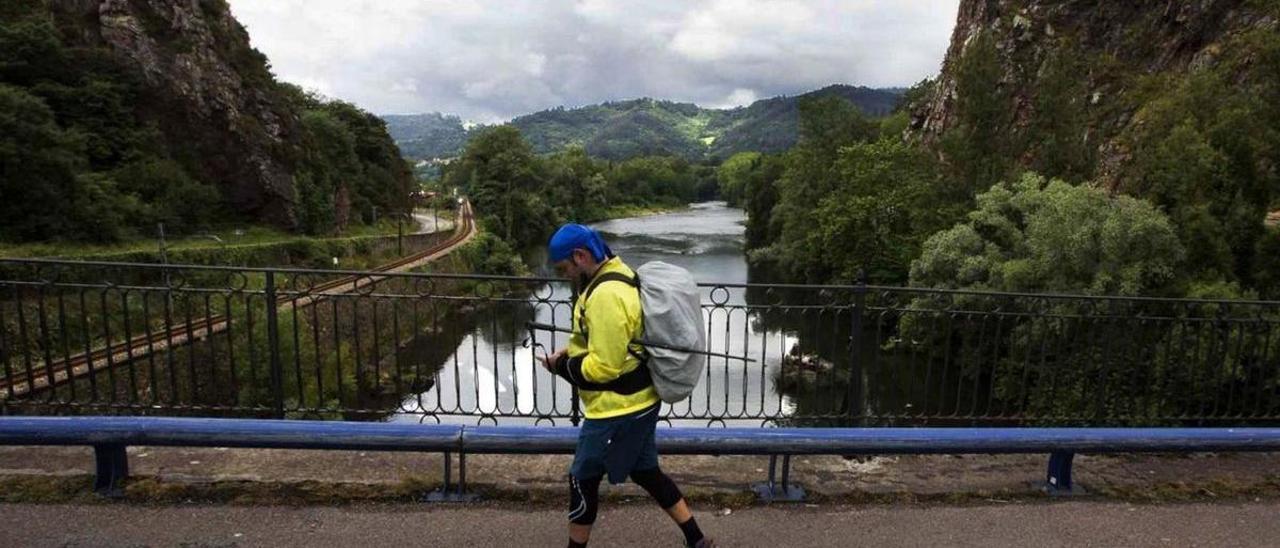 Un peregrino cruza el puente de Peñaflor en dirección a Grado, en una imagen de archivo. | Miki López