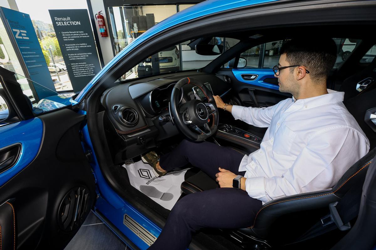 Un hombre dentro de un coche en un concesionario de Alicante.