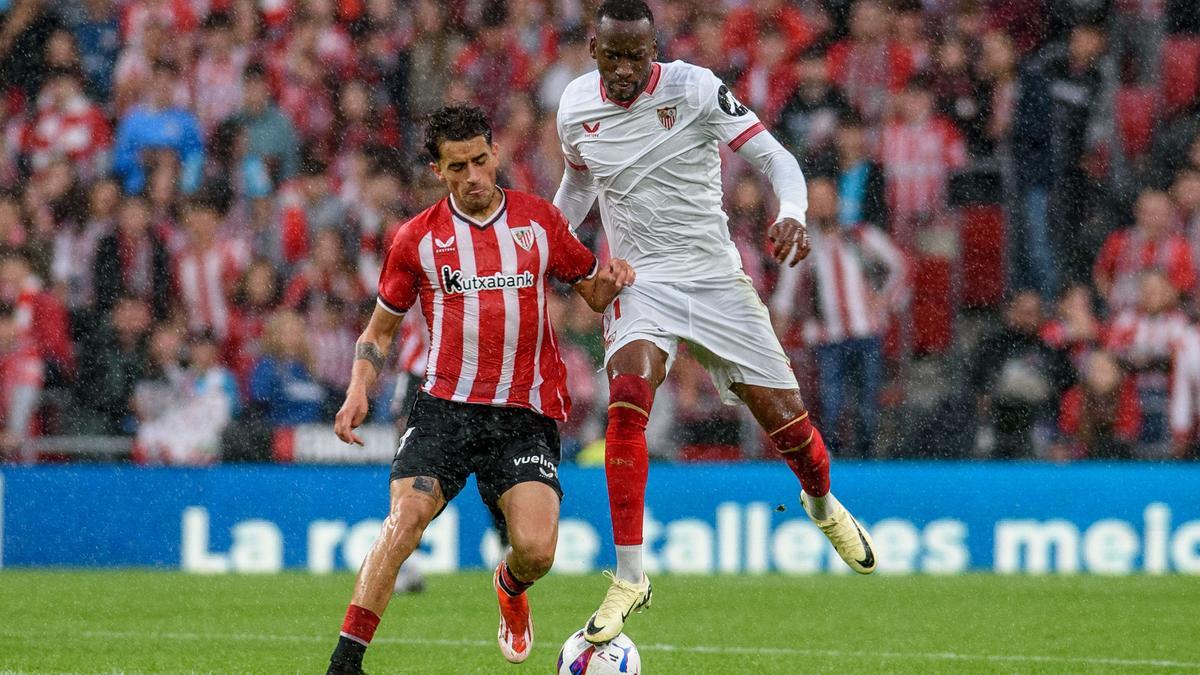 El delantero belga del Sevilla, Lukebakio, disputa el balón ante el jugador del Athletic, Prados, durante el partido de Liga en Primera División que Athletic Club y Sevilla FC disputan hoy domingo en el estadio de San Mamés.