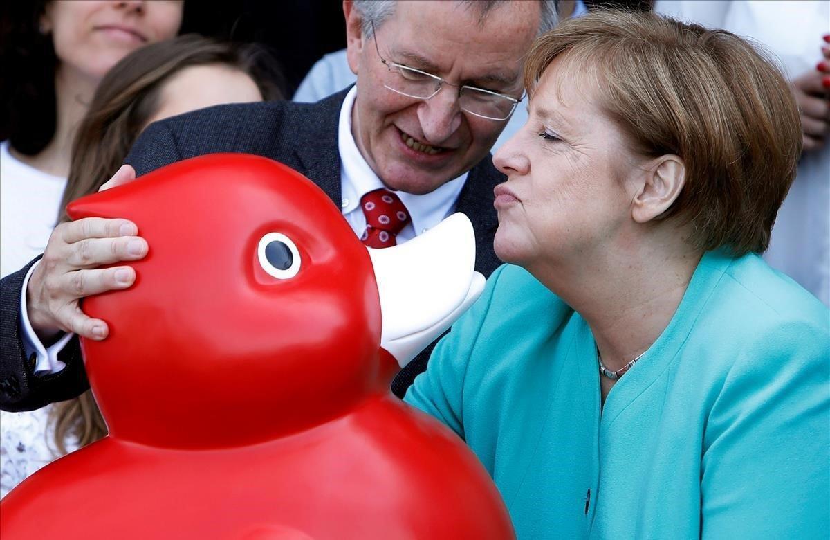 La cancillera alemana, Angela Merkel, recibe un pato de juguete en la visita la empresa de biotecnología ’Centogene’ en Rostock, Alemania.