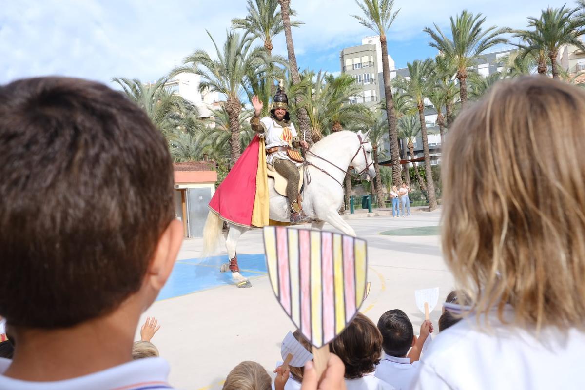 EL personaje de Jaime I saluda a los niños en el colegio Santa María de Elche