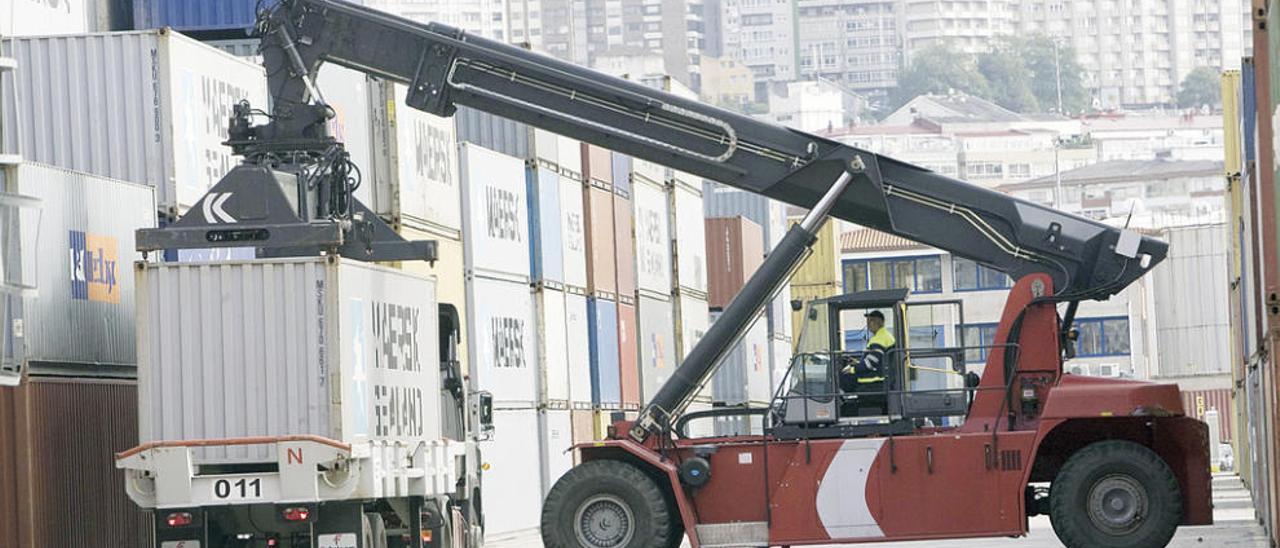 Un operario mueve con una grúa un contenedor de Maersk en la terminal de Guixar. // Ricardo Grobas