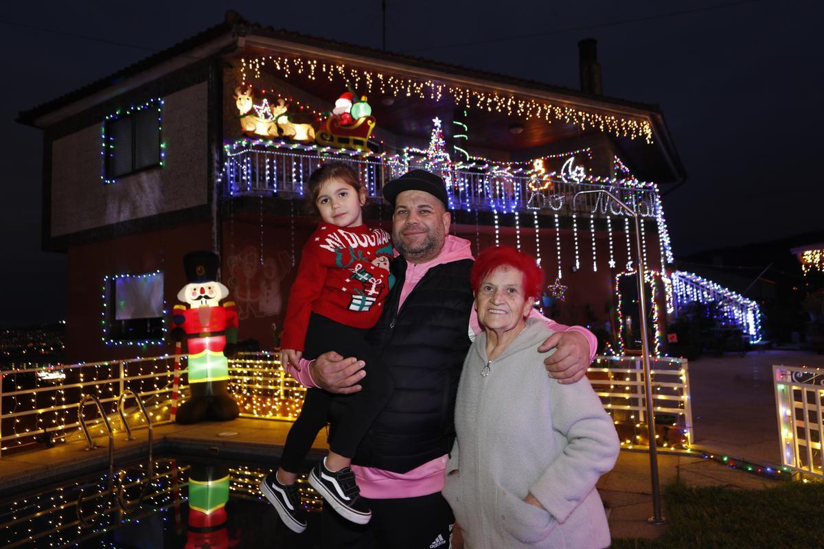 Juan Alberto Estévez, con su hija y su &quot;abuela Pachi&quot; ante su casa con una espectacular iluminación navideña.