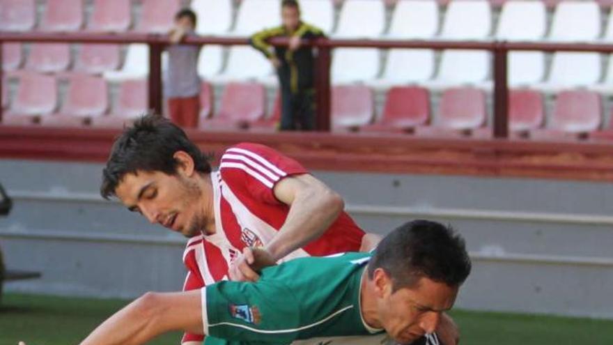 Un jugador del Coruxo protege un balón ante el acoso de un rival, ayer, en Las Gaunas. // La Rioja