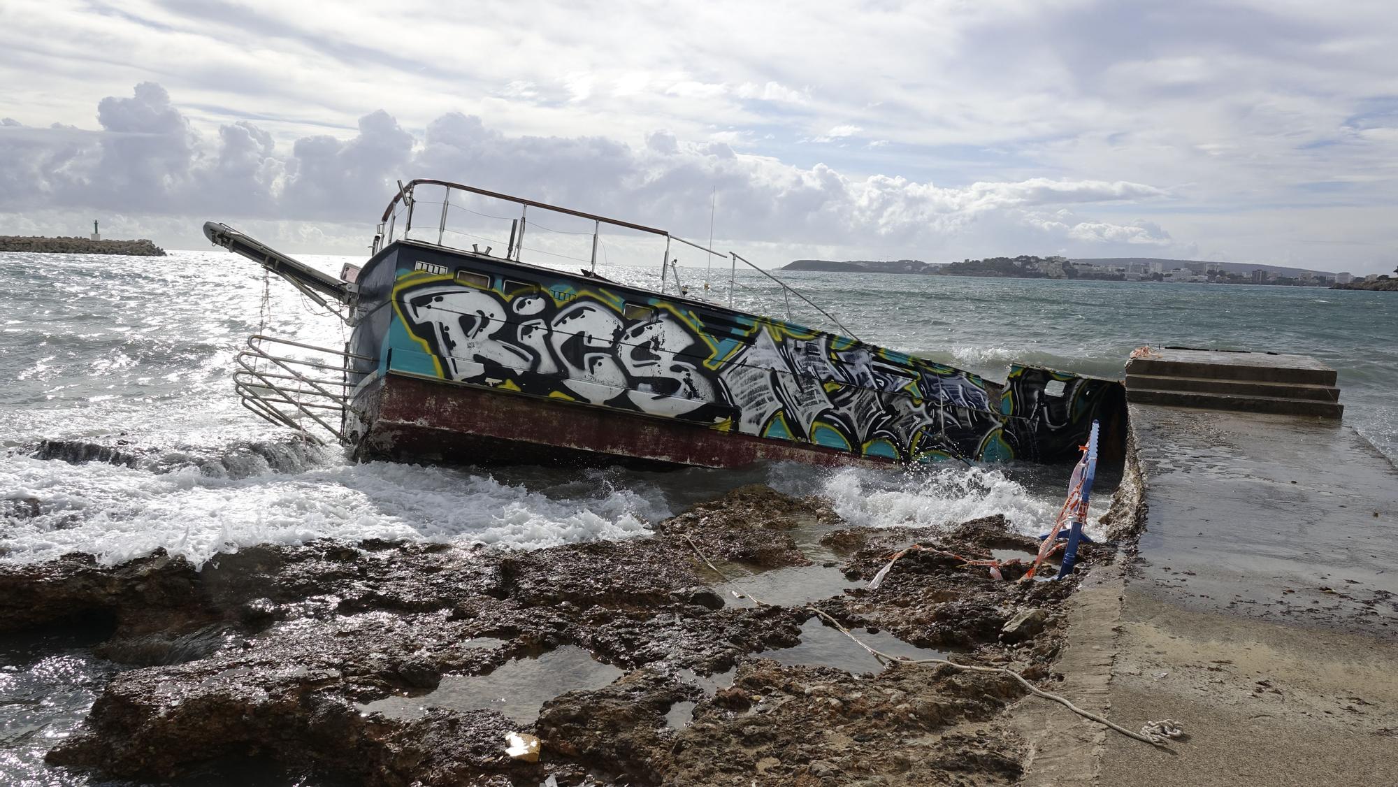 El oleaje destroza contra las rocas de Portals un barco varado