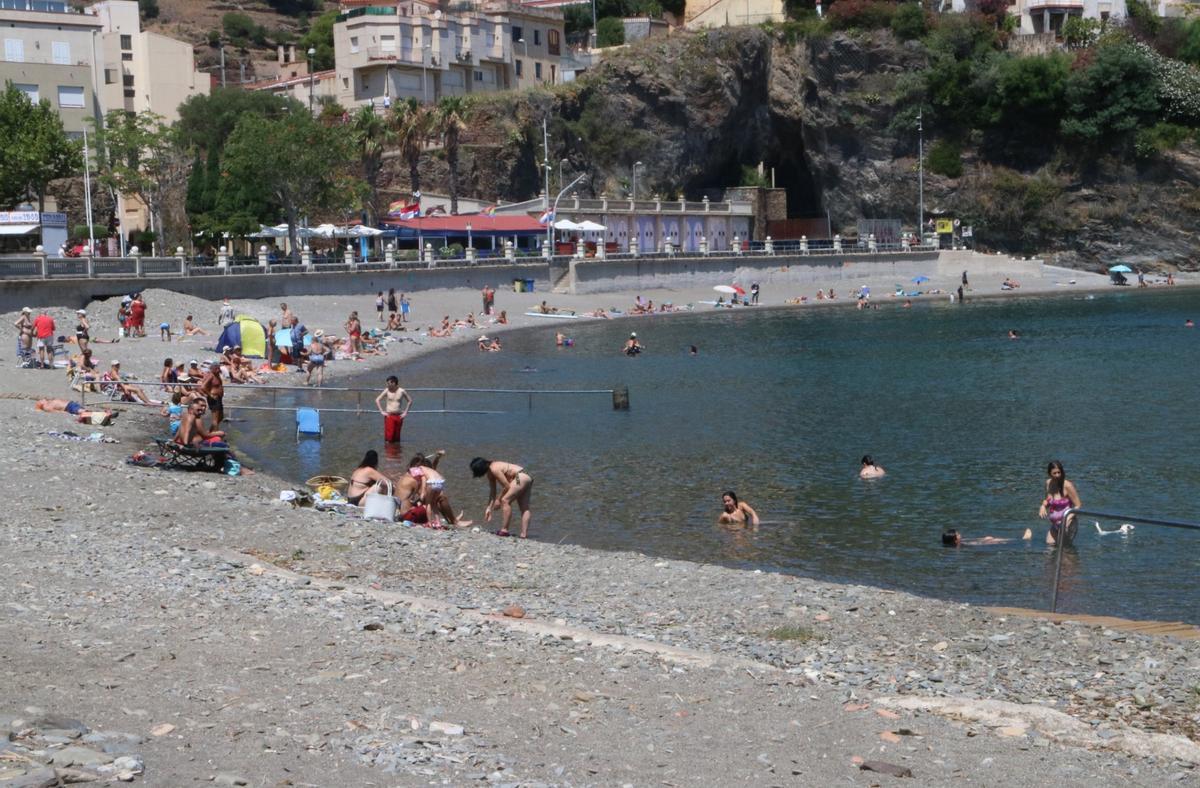 La platja de Portbou amb diversos banyistes.
