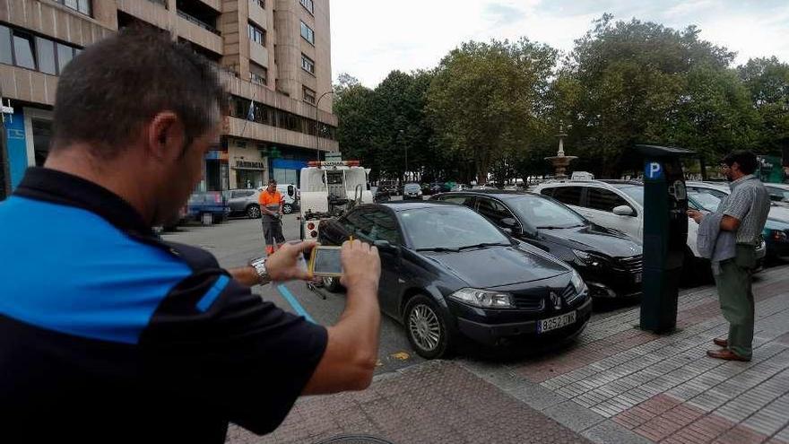 La grúa municipal, retirando un vehículo de la zona azul en la plaza de Pedro Menéndez.