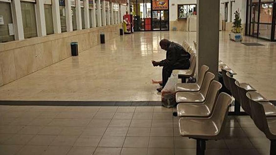 Un hombre comiendo un bocadillo en la zona de espera de la estación de autobuses. A. G.