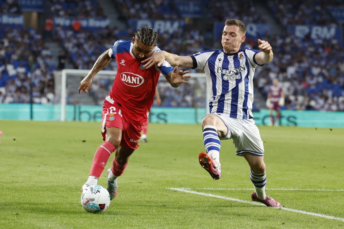 El delantero del Espanyol Tyrhys Dolan (i) juega un balón ante Sergio Gómez, de la Real, durante el partido de LaLiga de fútbol que Real Sociedad y RCD Espanyol disputan este domingo en el Reale Arena, en San Sebastián