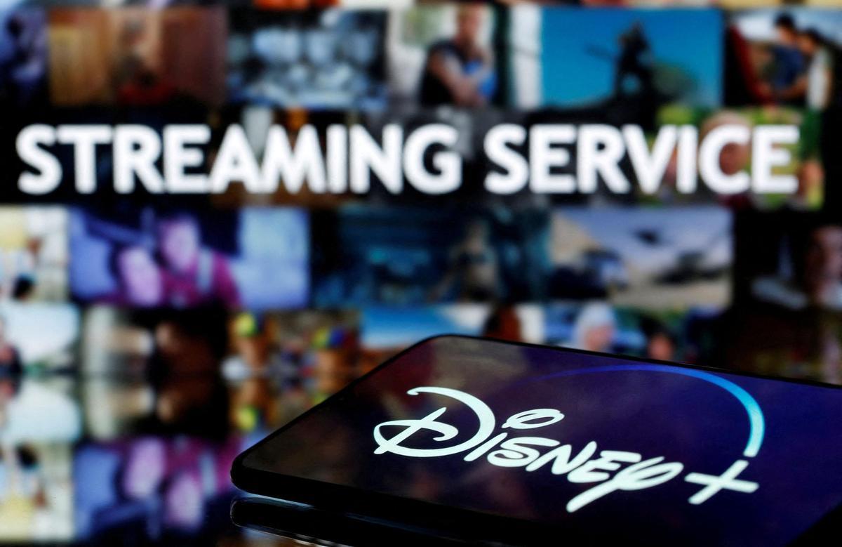 FILE PHOTO: A smartphone screen showing the Disney+ logo is seen in front of the words streaming service in this illustration
