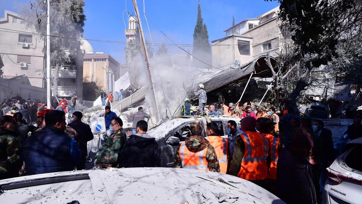 Soldados y trabajadores de los equipos de rescate, frente al edificio bombardeado este sábado en Damasco.