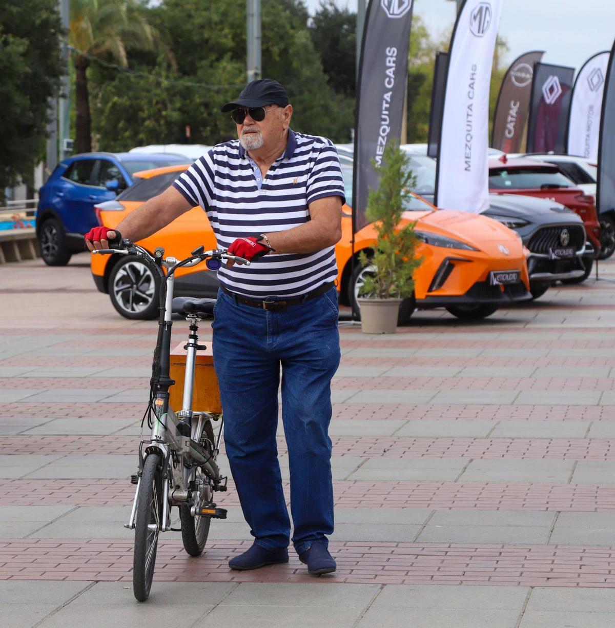 Un viandante con una bici en la reciente exposición de coches ECO e híbridos en el Paseo de Córdoba.