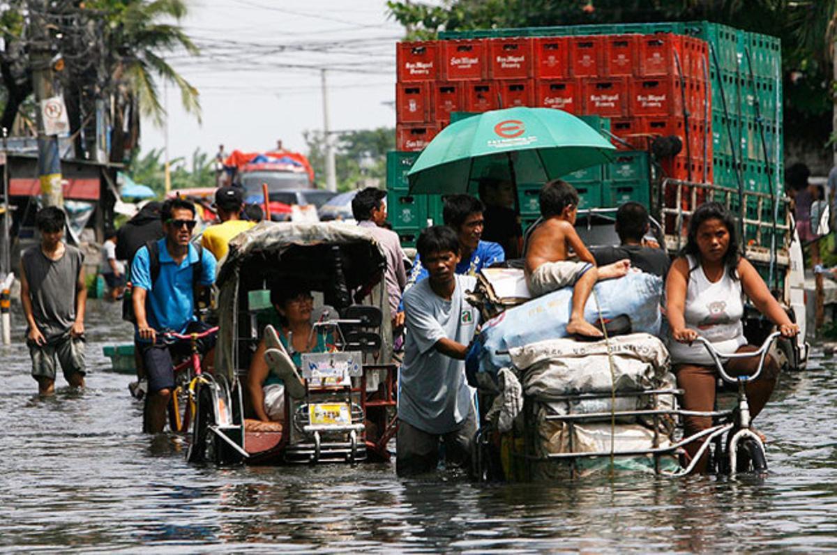 Ciutadans filipins han de viatjar amb l’aigua fins als genolls després del pas del tifó ’Butchoy’ per la ciutat de Malabon.
