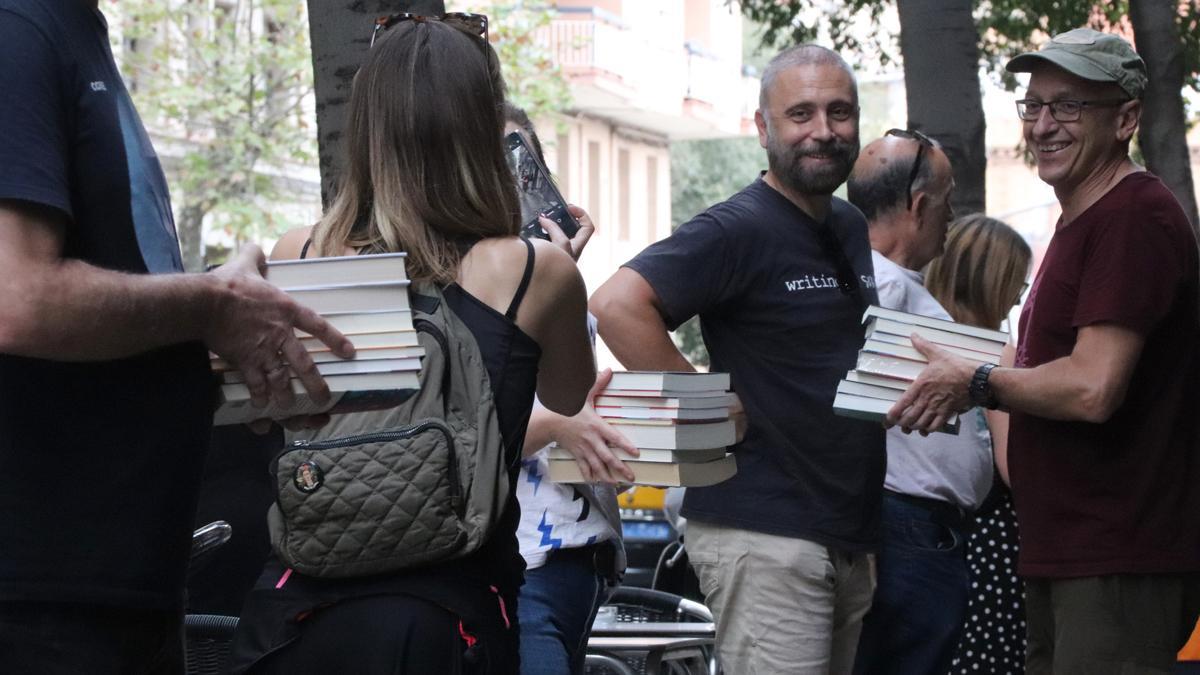 Una cadena humana traslada los libros de la librería Nollegiu del Clot al nuevo local