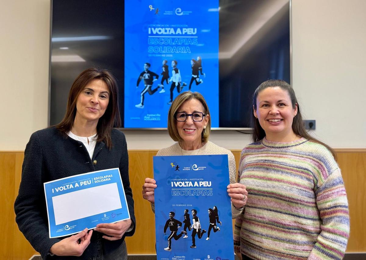 Representantes de Escolapias y organizadoras del evento con el cartel anunciador