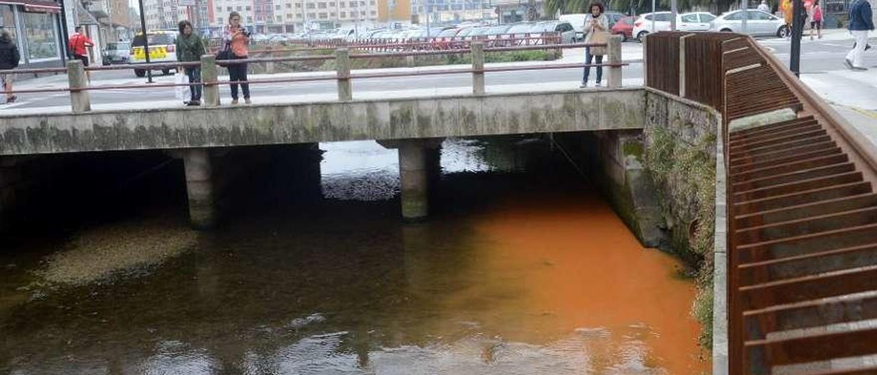 Las aguas del río de O Con teñidas de por la limpieza de la bomba de un garaje. // Noé Parga