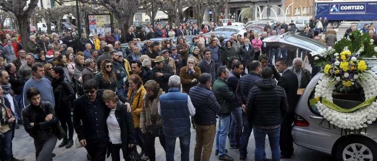 En primer término, uno de los hijos del fallecido y su viuda entran en la iglesia.