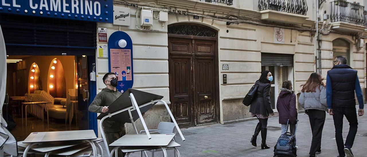 Un hostelero apila mesas
en un local de Russafa
.  g.caballero