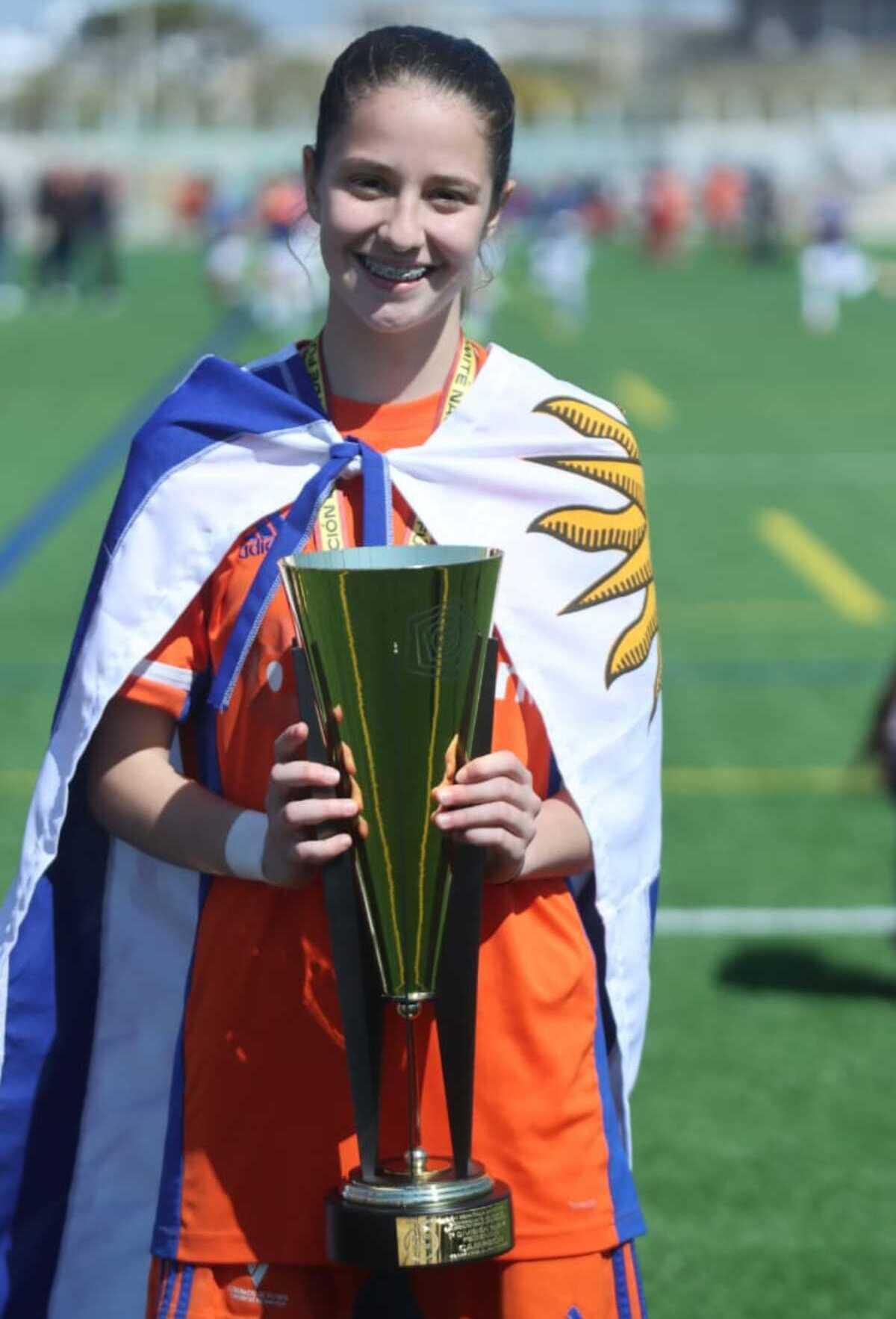 Laia sostiene con orgullo el trofeo de campeona