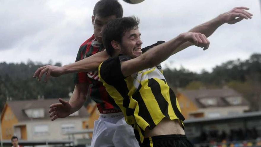 Paco intenta cabecear un balón en una disputa con un rival en un lance del partido ayer. // Noé Parga