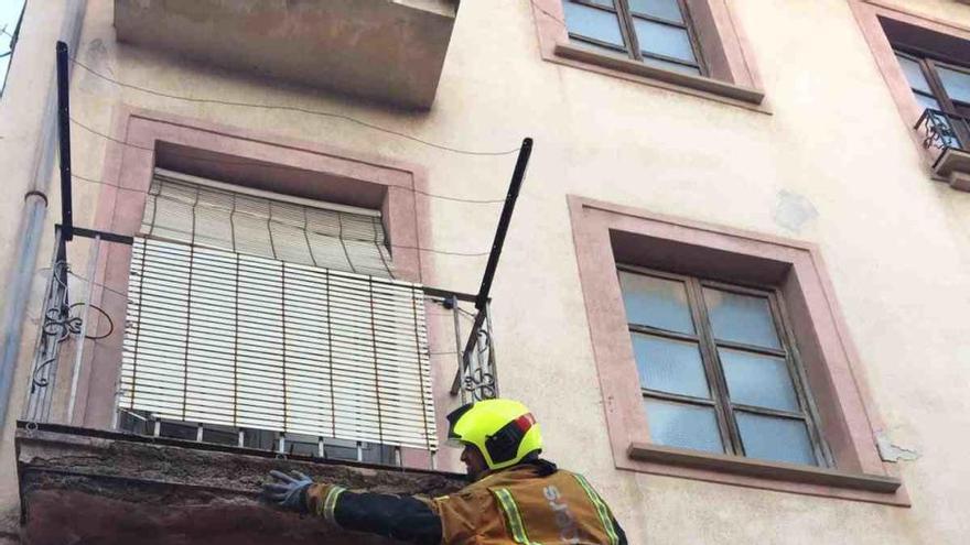 Un bombero trabajando en uno de los balcones de la casa