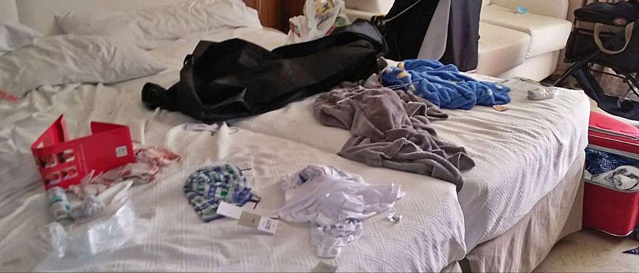 Ropa, basura y suciedad por encima de camas y mesas en la habitación de un hotel de Benidorm.