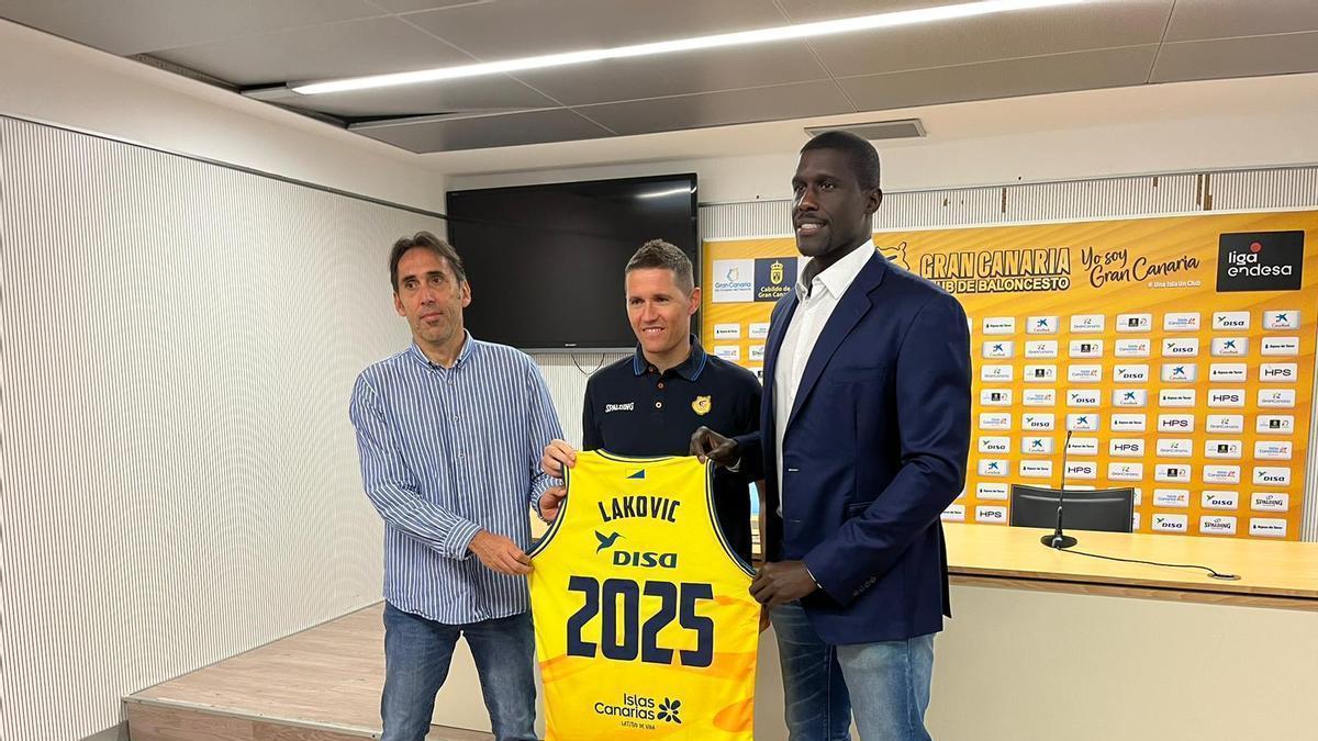 Lakovic posa con una camiseta del Granca con su nombre y el número 2025, flanqueado a la izquierda por Willy Villar y a la derecha por Sitapha Savané