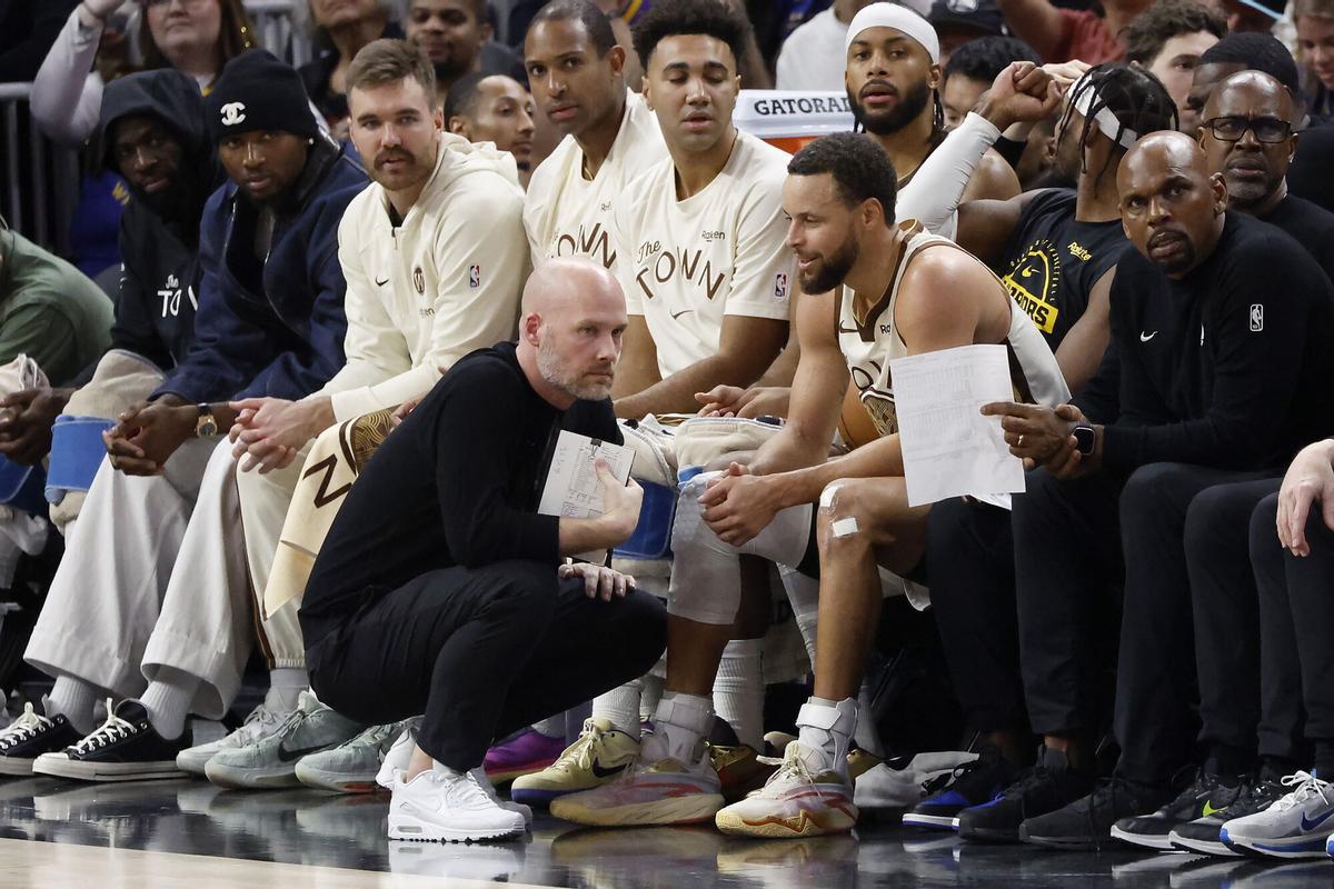 Curry habla con el trainer de los Warriors, Drew Yoder para conocer el estado físico de la estrella del equipo de la Bahía de San Francisco