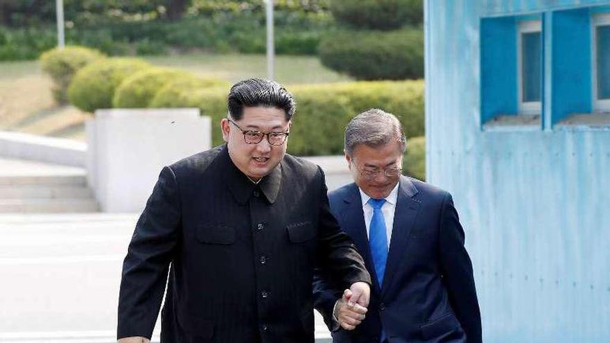 Kim coge de la mano a Moon para cruzar juntos hacia el Norte. // Efe