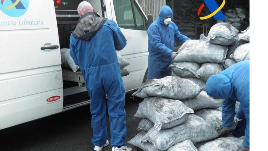 Funcionarios del SVA introducen en el escáner móvil sacos de carbón vegetal en busca de la cocaína.