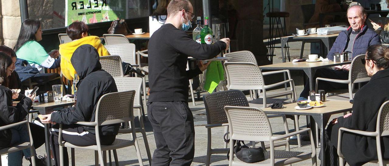 Un camarero atiende la terraza en una cafetería de la Praza Maior de Ourense. |   // IÑAKI OSORIO