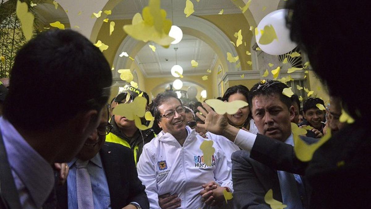 Gustavo Petro vuelve a su despacho en la alcaldía de Bogotá entre pétalos amarillos.