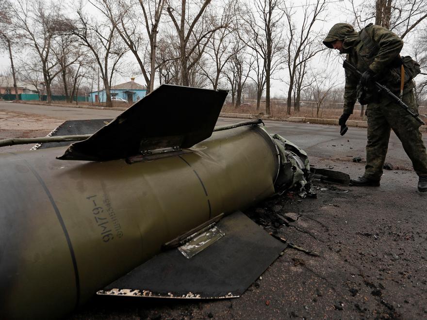 Un soldat prorús inspecciona les restes d'un míssil en un carrer de Donetsk