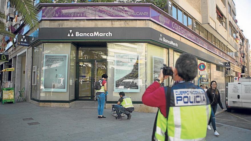 Imágenes de la Policía Nacional realizando la inspección en la oficina de Alicante que sufrió un intento de atraco.